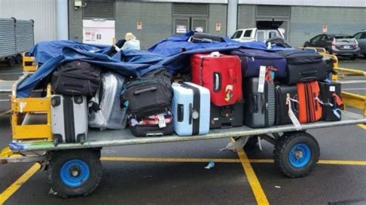Airport luggage trolleys soaked, stored outside in torrential rain